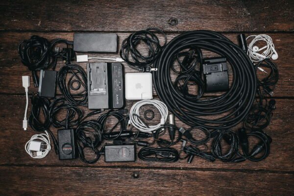many chargers and cables on a wooden desk