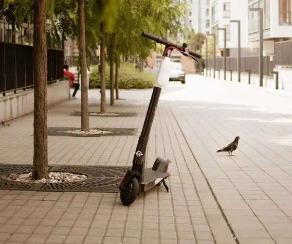 rental Bird electric scooter leaning on its stand in an urban environment