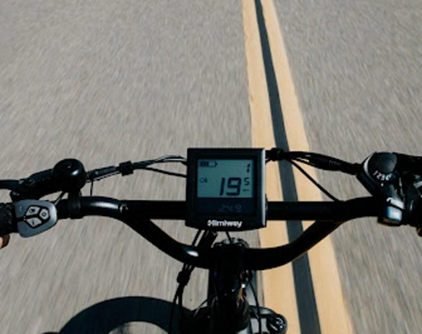 A closeup of an electric bike display with the road ahead