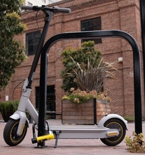 A closeup of an electric scooter locked securely with a U-lock