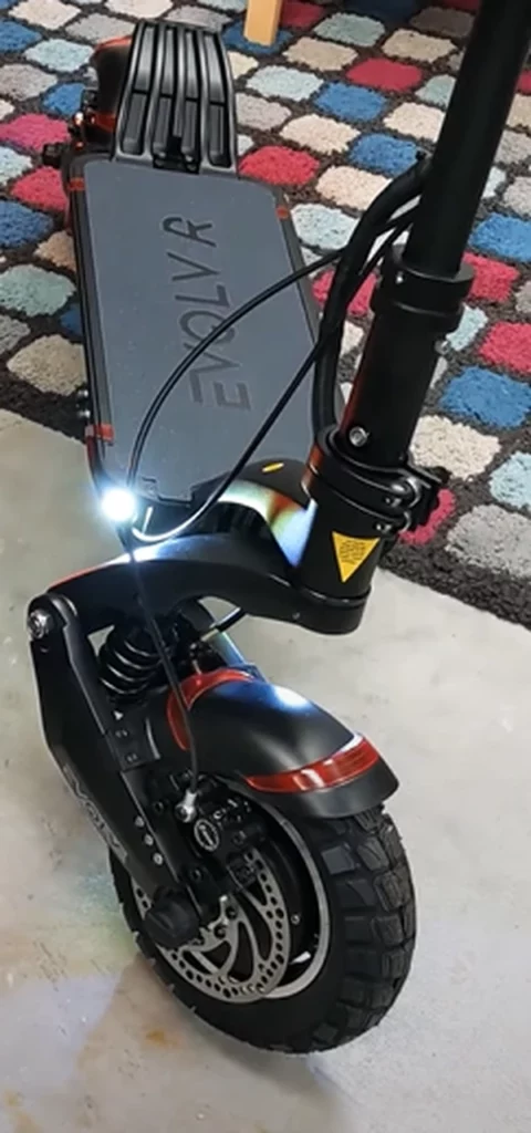 A closeup of the deck, rear kick plate, front tire and deck lights of the EVOLV Pro-R