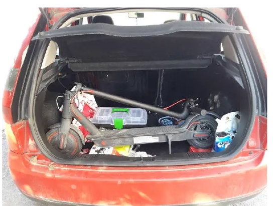 An electric scooter stored in a car trunk