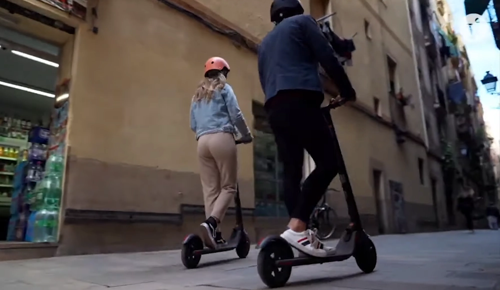 a couple riding Ninebot ES4 electric scooters