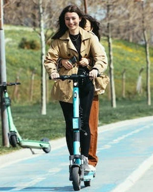 Two girls riding one electric scooter