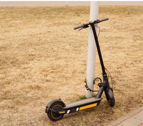 An electric scooter secured to a post