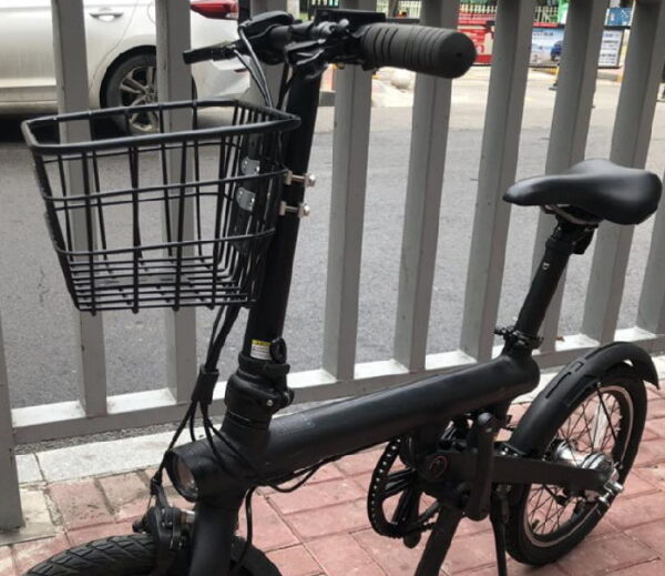 black electric scooter with seat and a basket installed on the front of the stem
