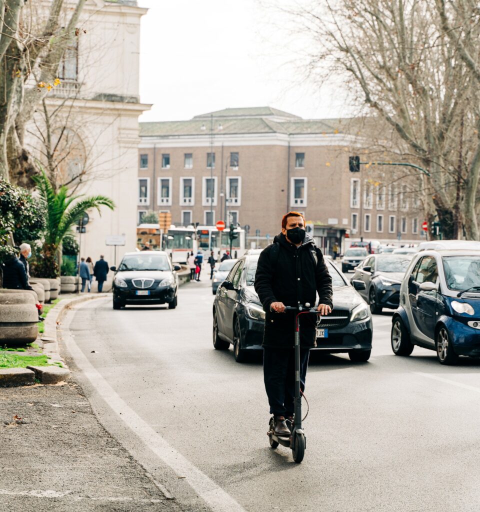Man riding a scooter in traffic