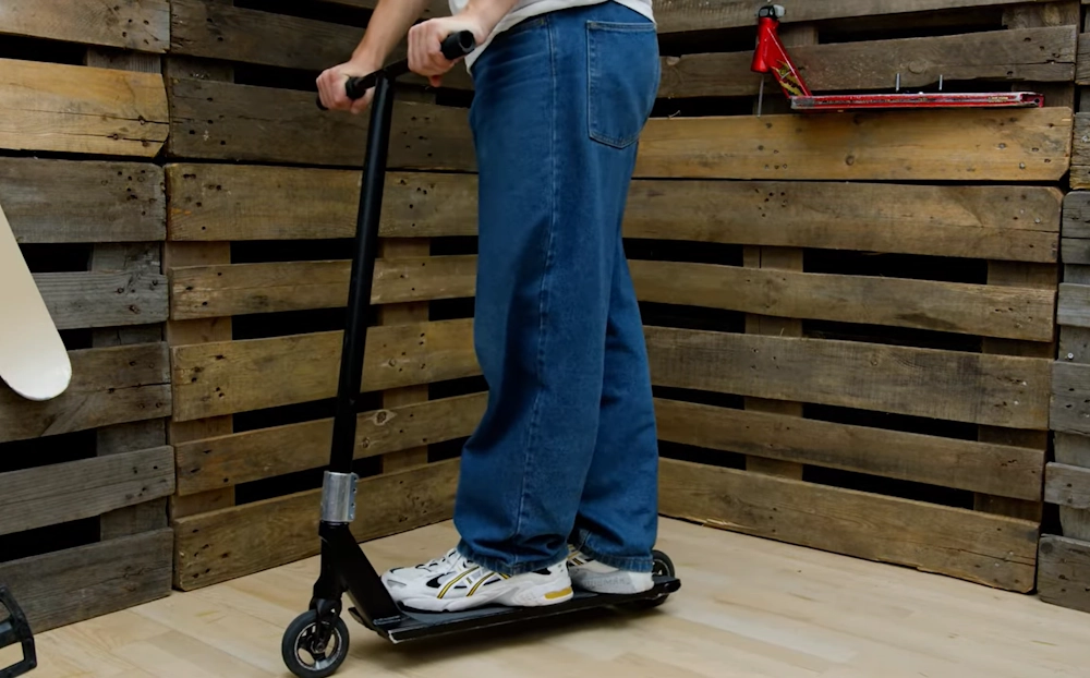 guy demonstrating how high should electric scooter handlebar be.