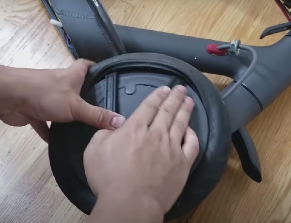 removing a flat tire from the wheel of an electric scooter