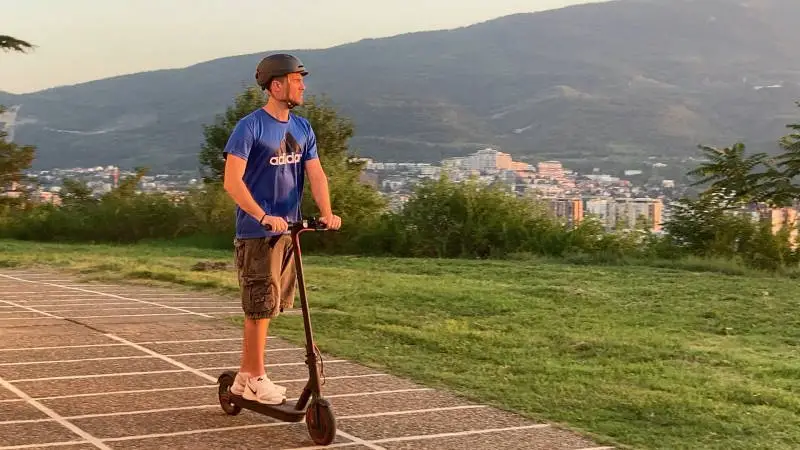 person riding an electric scooter while not being entirely focused and minding the road ahead