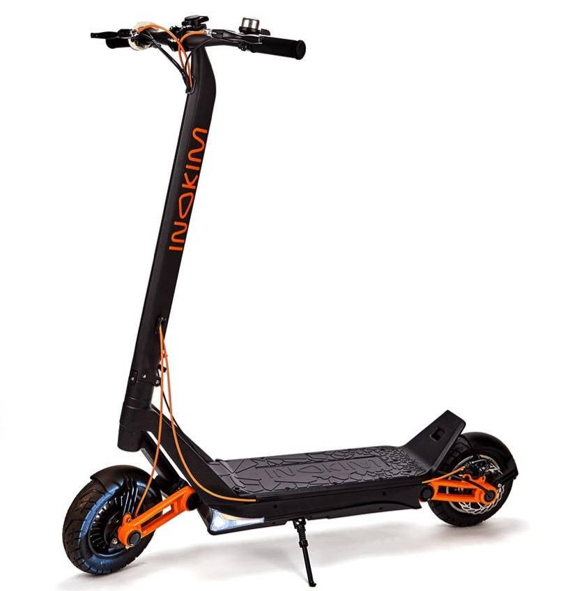 side view of the Inokim OX electric scooter with orange details leaning on its stand on white background