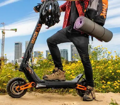 person standing with one leg on the deck of an Inokim OXO electric scooter after climbing