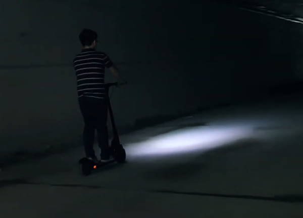 a person riding the Kugoo M2 Pro at night with the lights on