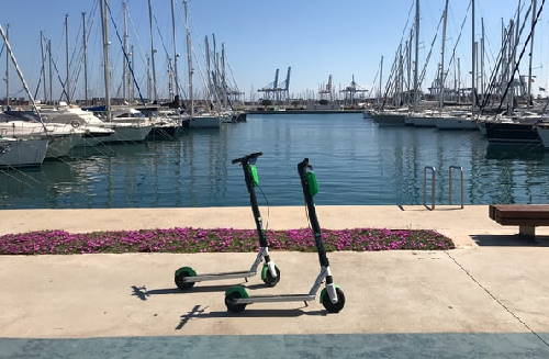 two Lime rental electric scooters on a dock