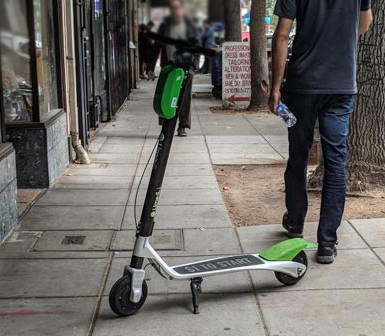 a Lime scooter leaning on the sidewalk