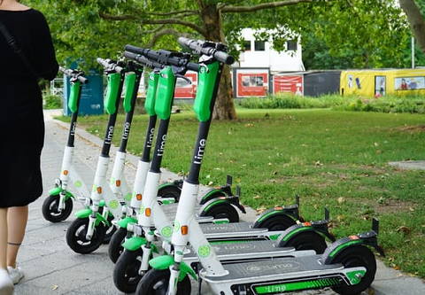 several Lime rental electric scooters parked on a sidewalk