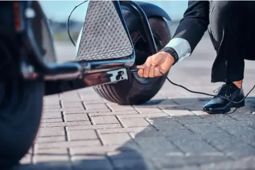 A man charging an electric scooter on