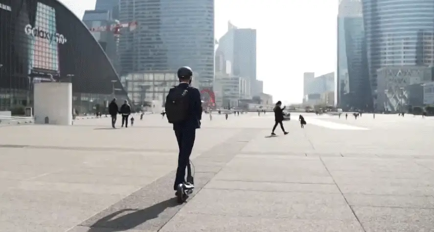 person riding a Ninebot Max electric scooter in an urban setting