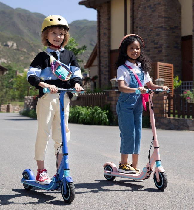 two kids riding Ninebot Zing E8 electric scooters