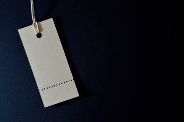 empty white perforated price tag on a dark blue background
