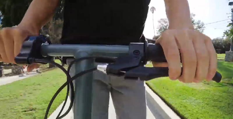 person pressing the brake lever on a Razor E300