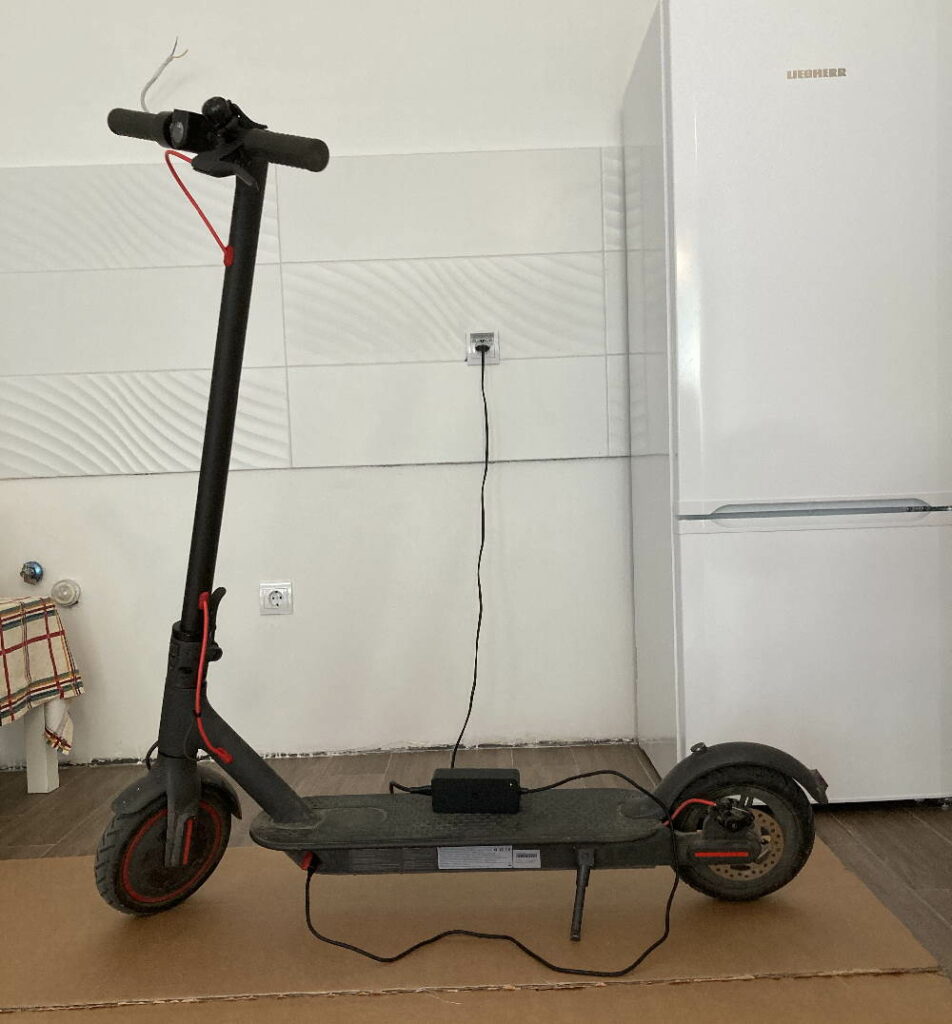 scooter and charger visible, while the scooter is connected to the charger