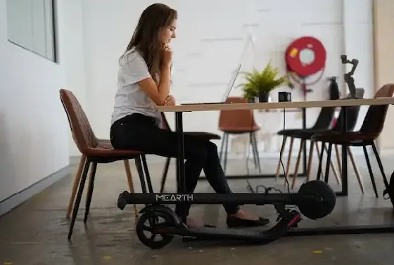 small and portable electric scooter stored under a desk