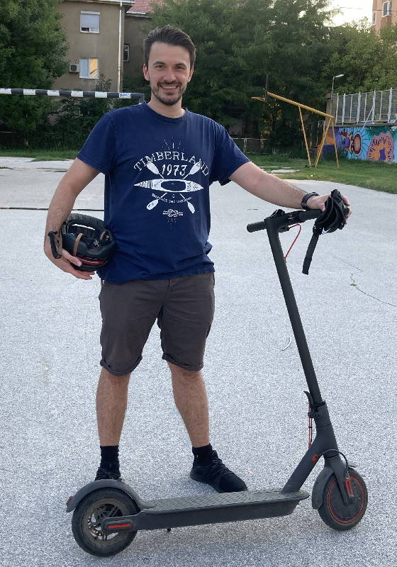author and editor Matt of EScooterNerds standing next to his Xiaomi M365 Pro electric scooter