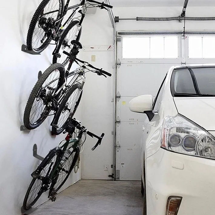 three electric bikes on storage racks in a garage