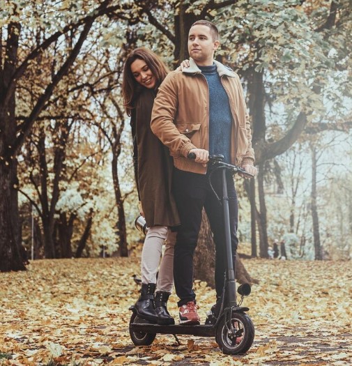 two people on a scooter in a park