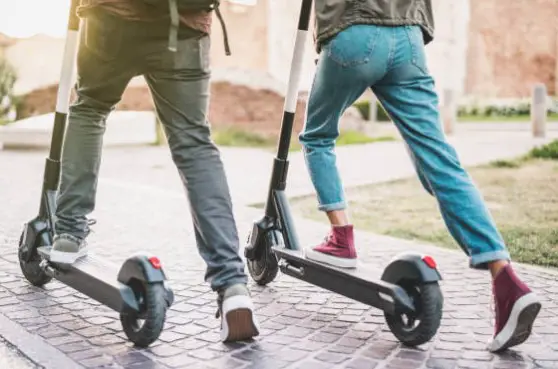 two people riding on an e-scooter side-by-side