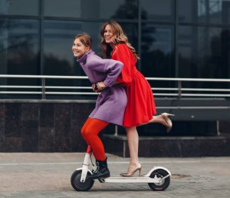 two women riding on an e-scooter