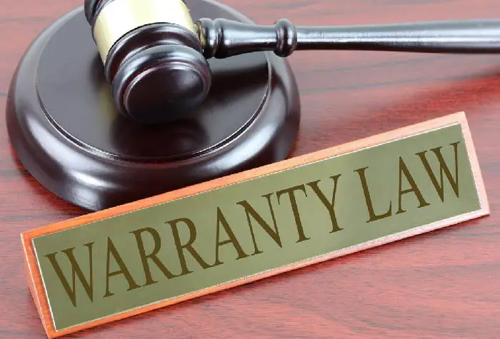 judge's hammer on a desk next to a sign that says warranty law