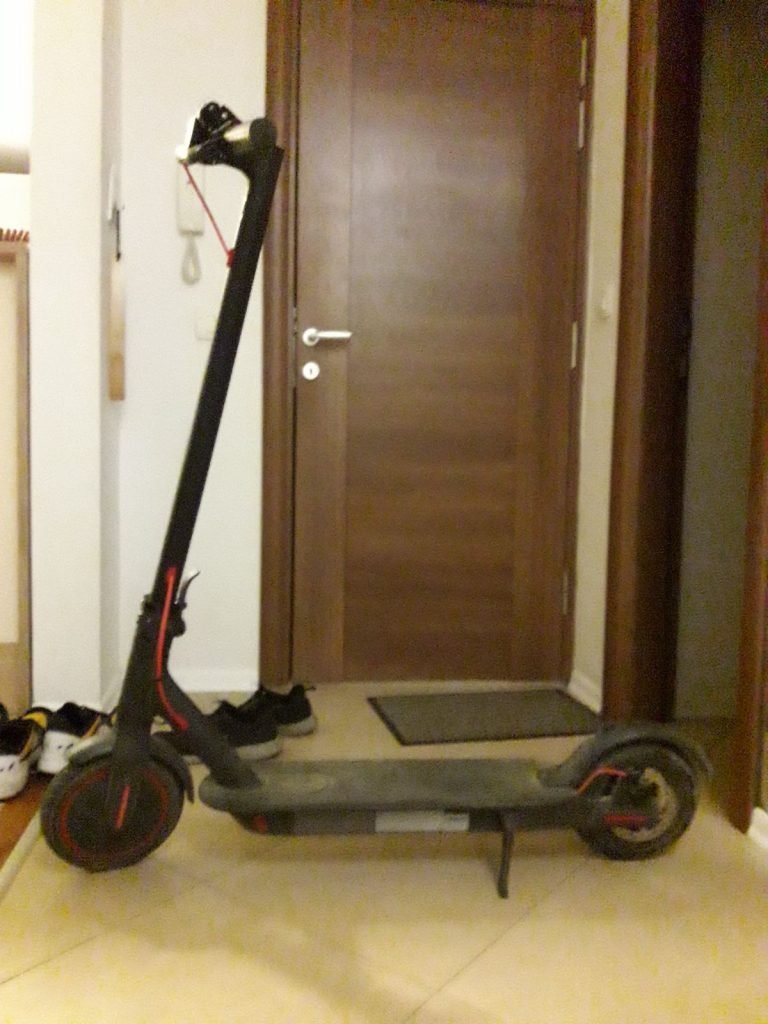 side view of Xiaomi M365 Pro standing on a stand in a living room