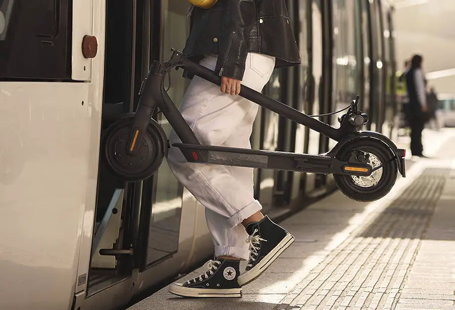 person carrying a folded Xiaomi Essential in the train