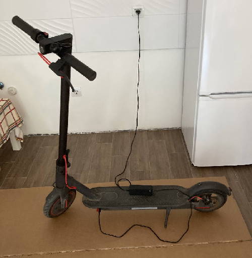 charging a Xiaomi M365 Pro electric scooter in a garage