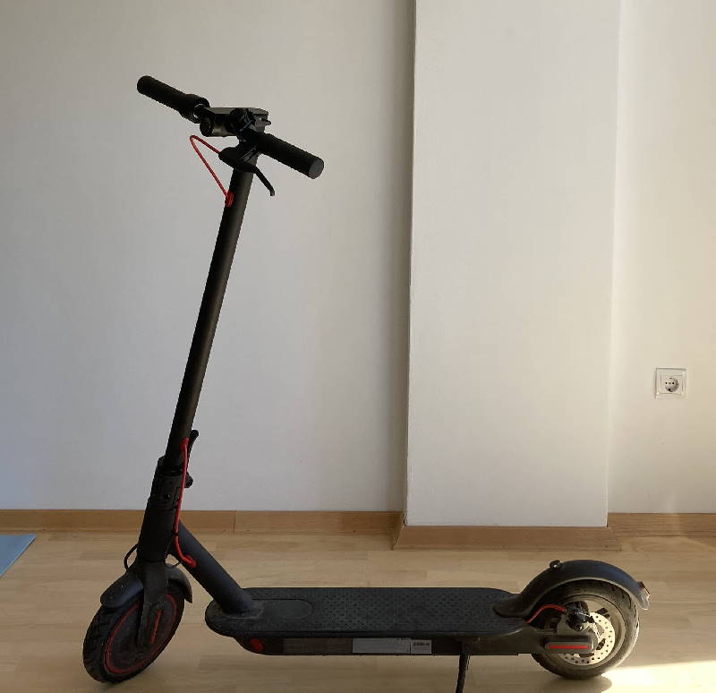 Xiaomi M365 Pro electric scooter leaning on its kickstand in a living room